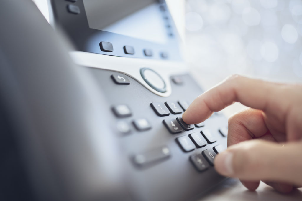 Dialing a telephone in the office concept for communication, contact us and customer service support